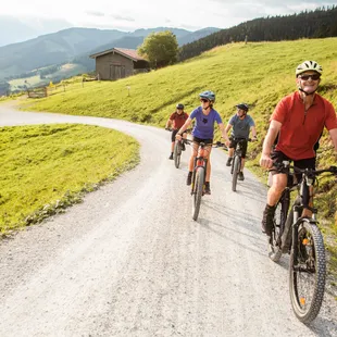 Ihr Mountainbike Urlaub Gruppe von Radfahrern auf Mountainbikes auf einem Schotterweg durch eine idyllische Landschaft